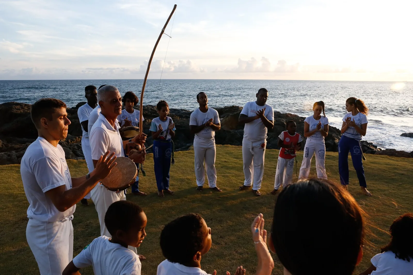 Roda de capoeira aberta com berimbau e participantes em movimento, Salvador
